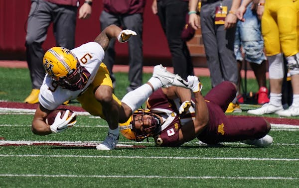 Gophers wide receiver Daniel Jackson (9) was tackled with the ball in the first quarter.