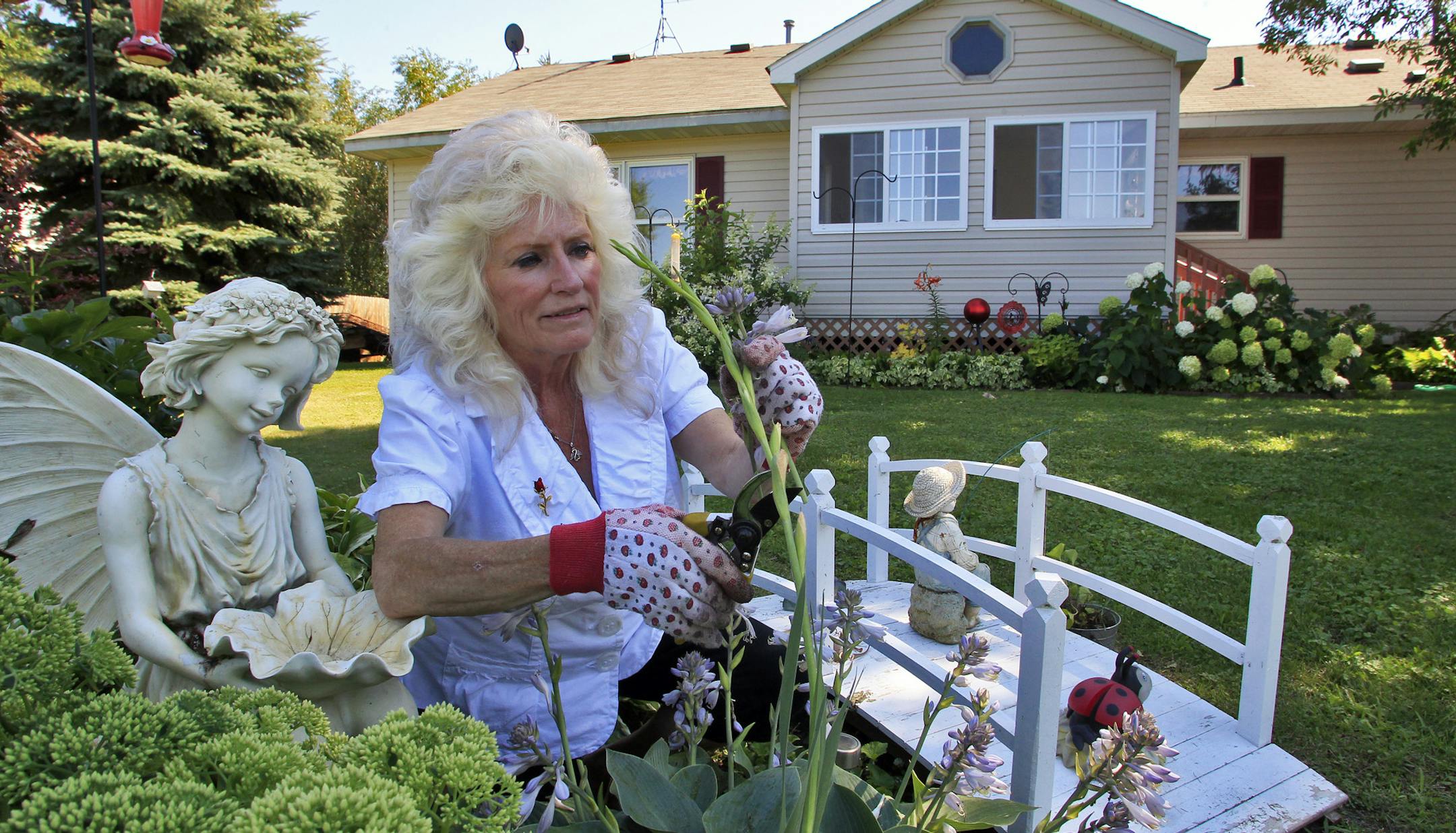 Mardee Jerde of Rush City has lived in her home on Rush Lake for the past 16 years, but is in danger of having a Chase Financial home loan foreclosed on when she was unable to work due to an accident in 2008. Mardee Jerde worked on he flower garden in the backyard of her home. Wednesday, August 3, 2011. ](MARLIN LEVISON/STARTRIBUNE ) mlevison@startribune.com (cq Mardee Jerde) ORG XMIT: MIN2013063016170979
