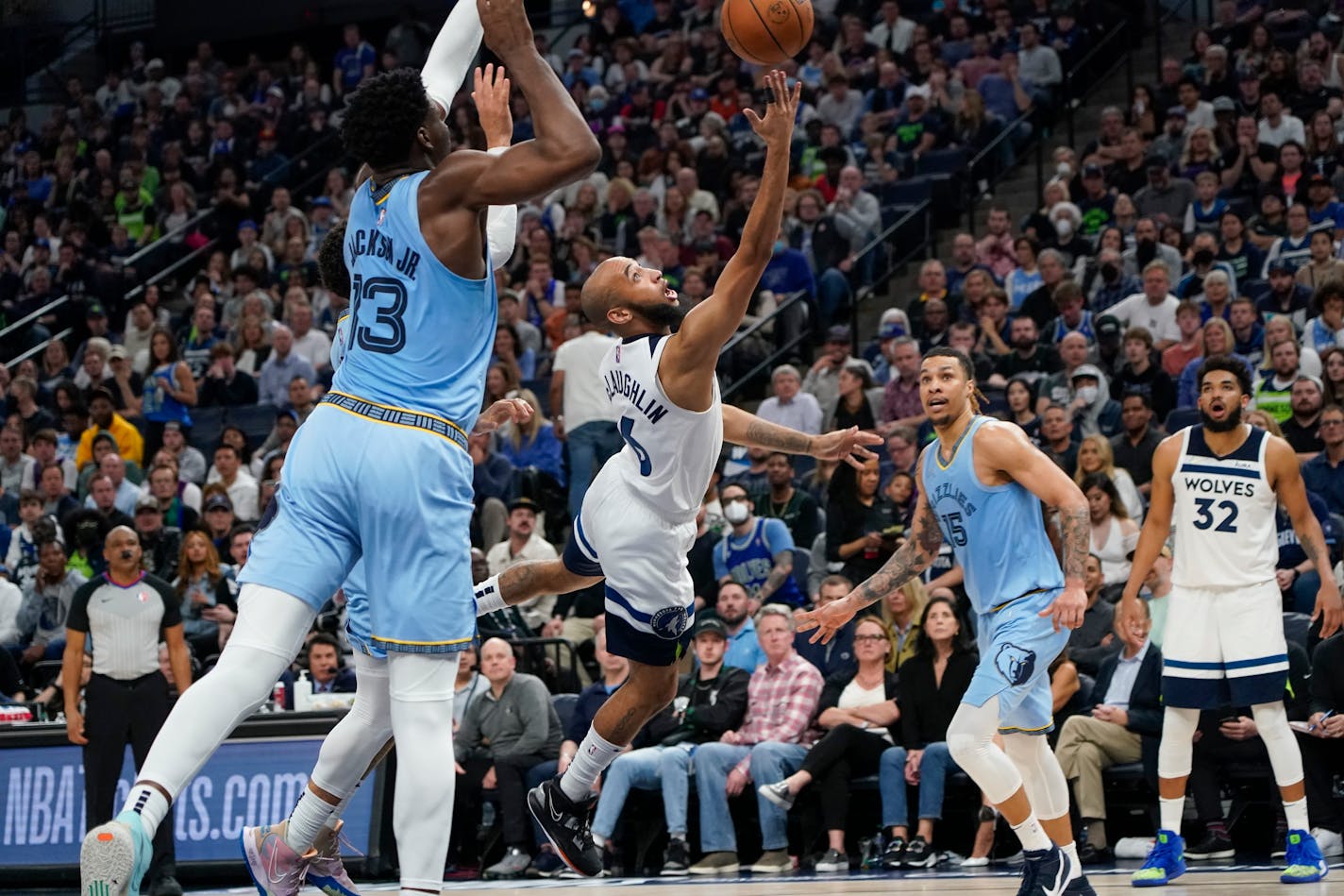 Minnesota Timberwolves guard Jordan McLaughlin, center, goes up for a shot between Memphis Grizzlies forward Jaren Jackson Jr., left, and Grizzlies forward Brandon Clarke, right, during the second half in Game 4 of an NBA basketball first-round playoff series Saturday, April 23, 2022, in Minneapolis. The Timberwolves win 119-118. (AP Photo/Craig Lassig)