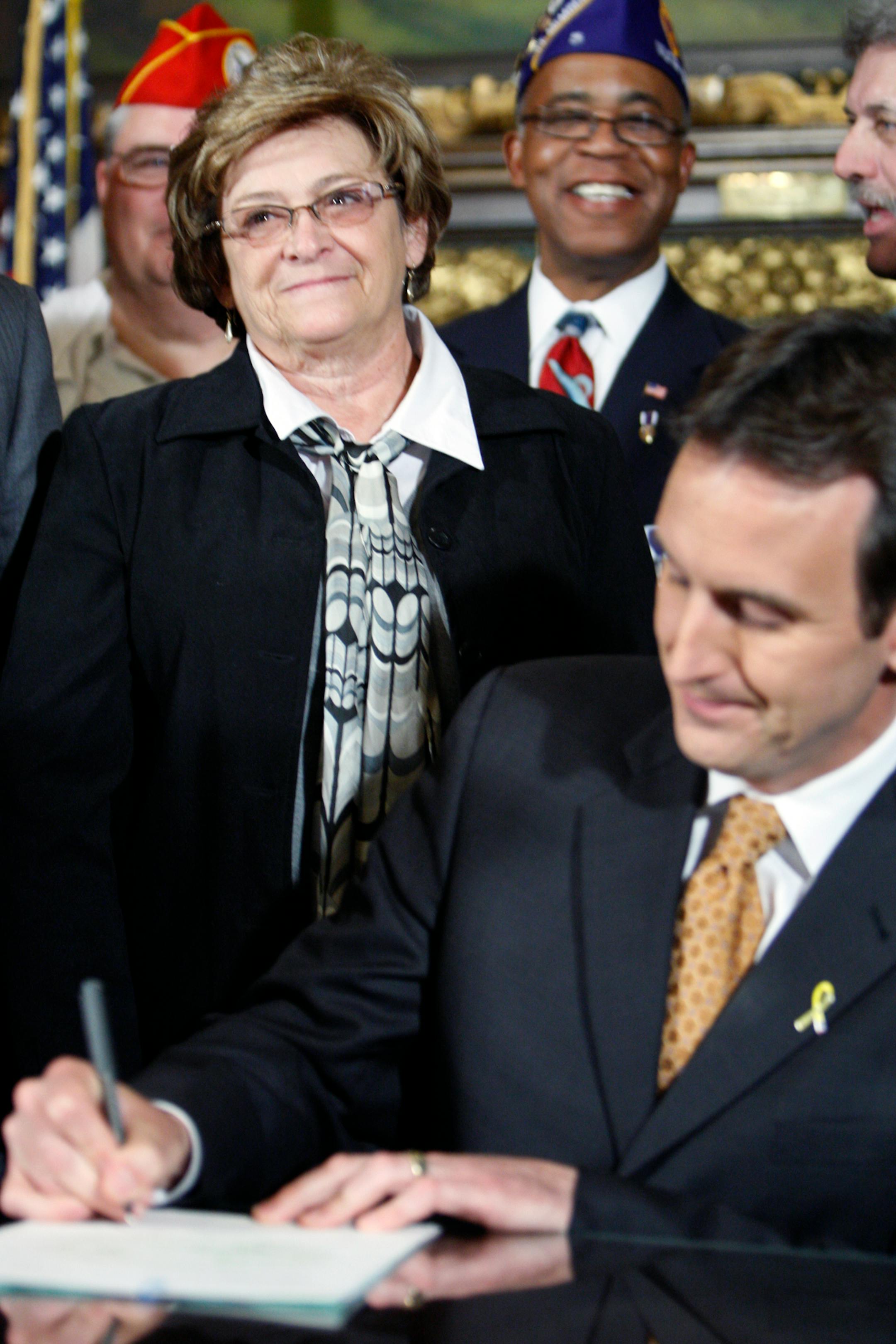 Diane Finnemann watched as Gov. Tim Pawlenty signed a bill that designated March 29 as Vietnam Veterans Day. Her brother, Wallace R. (Skip) Schmidt, committed suicide in 1972 after returning from Vietnam. She was instrumental in the bill's creation.