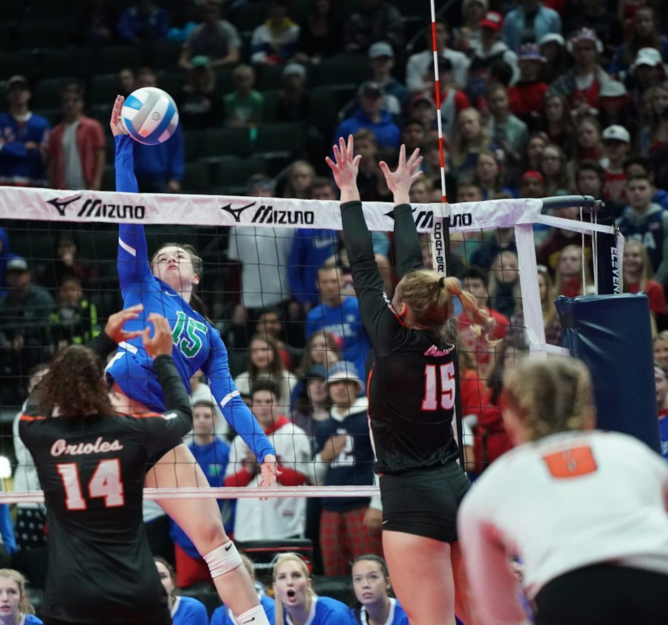 Eagan outside hitter Christine Jurgens (15) hit at the net as St. Louis Park's Raegan Alexander (14) and Makaila Winward (15) tried to block in the first game. Eagan swept the match to move into the semifinals.