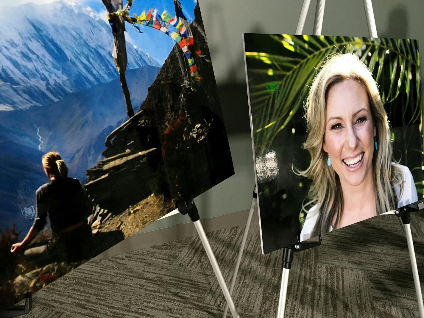 FILE - In this July 23, 2018, file photo, posters of Justine Ruszczyk Damond are displayed at a news conference by attorneys for her family in Minneapolis. A lawsuit filed by the family of Ruszczyk Damond who was fatally shot by a Minneapolis police officer last year has been put on hold while a criminal case against the officer proceeds. U.S. Magistrate Judge Tony Leung ruled Tuesday, Oct. 2, 2018, that the $50 million civil rights lawsuit filed by the father of Ruszczyk Damond will be delayed