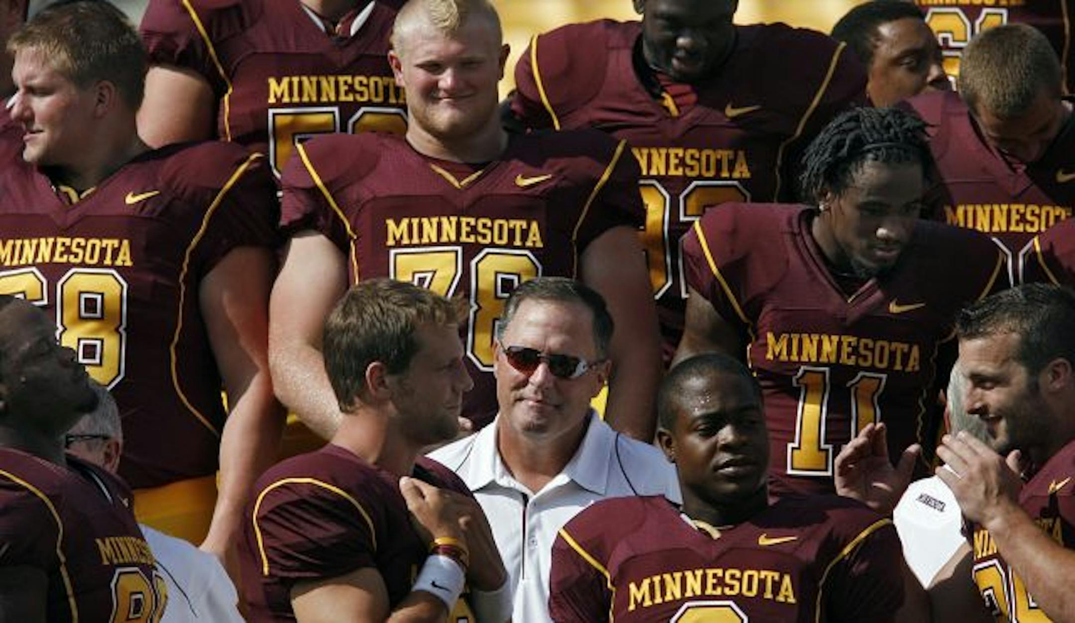 Gophers football coach Tim Brewster was surrounded by his 2010 players during a team photo.