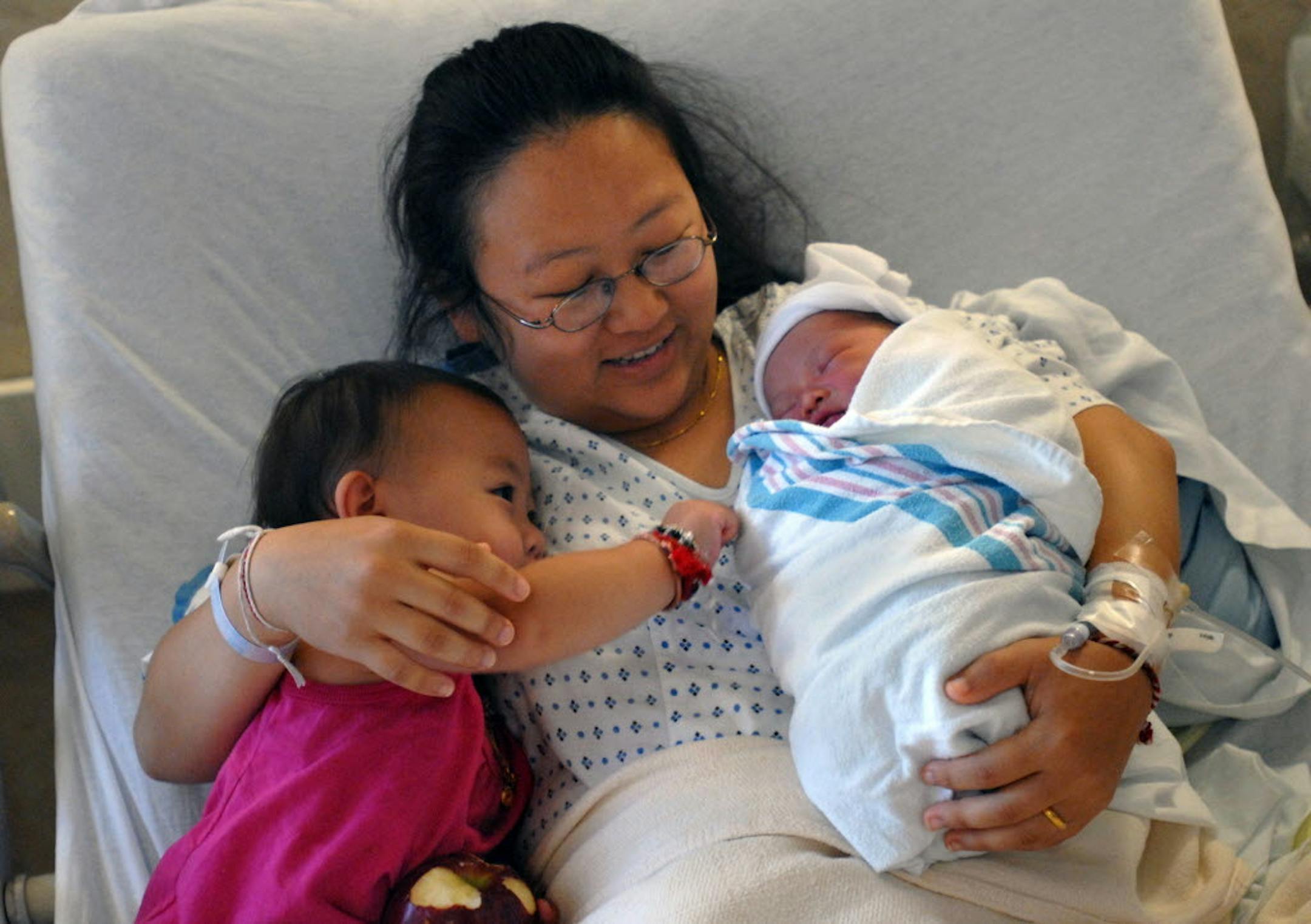 New mother Pang Yang held her 18-month-old daughter, Syndney Lee, and her newborn daughter, Cecilia Lee. Cecilia is counted as one of the 16 babies born in 17 hours at Regions Hospital. Yang actually gave birth to Cecilia in her bathroom at home.
