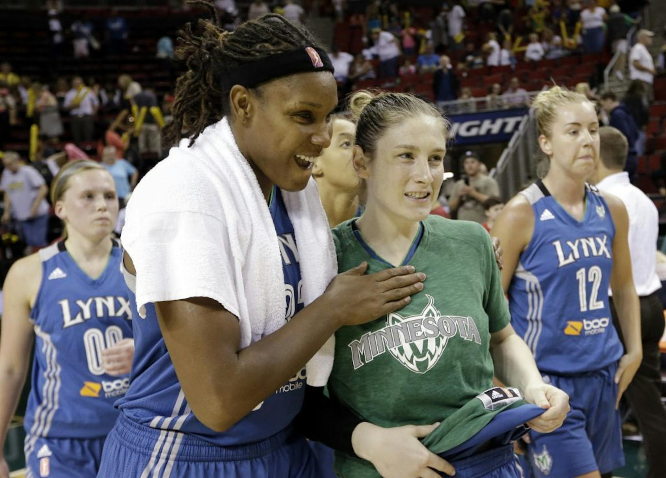 Minnesota Lynx's Rebekkah Brunson, second left, and Lindsay Whalen smile after the team beat the Seattle Storm in a WNBA basketball game Tuesday, Sept. 10, 2013, in Seattle. The Lynx won 73-60.