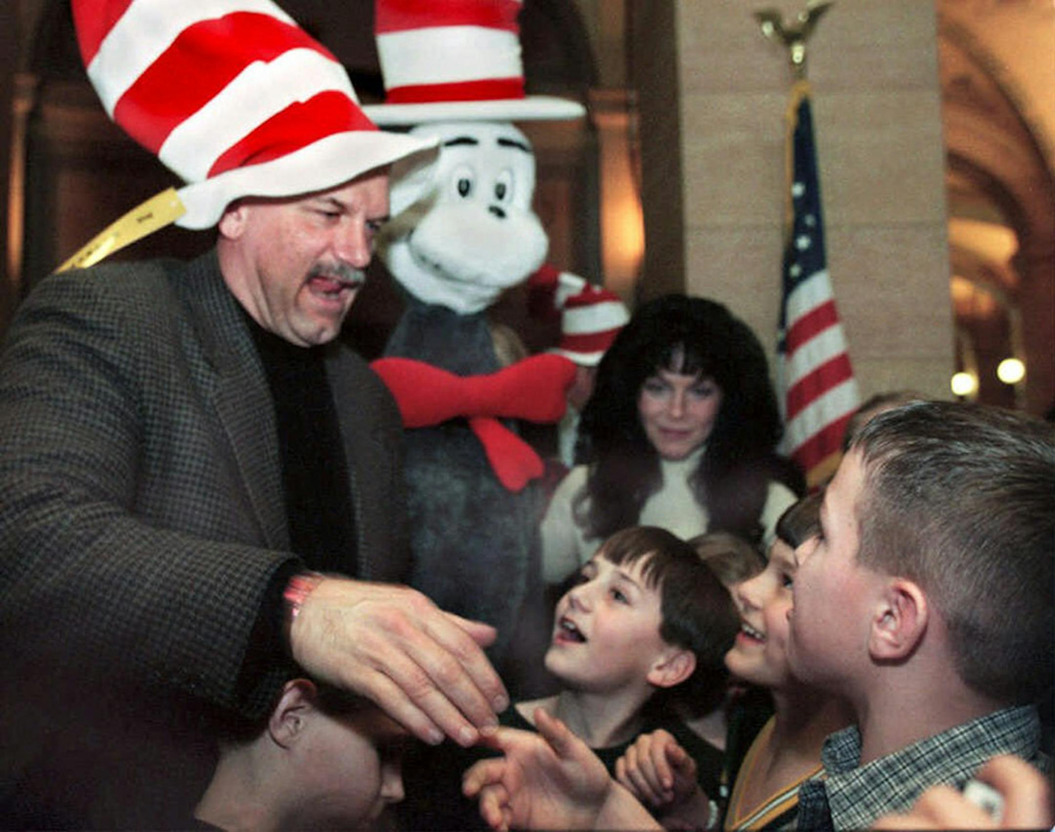 Minnesota Gov. Jesse Ventura wearing a Dr. Suess cat in the hat hat shakes hands with children for coming to the capitol to listen to Lt. Gov. Mae Schunk, first lady Terry Ventura and himself read aloud Monday, March 1, 1999, in St. Paul. Tuesday, March 2, is the birthday of Dr. Seuss and Read Across America day.