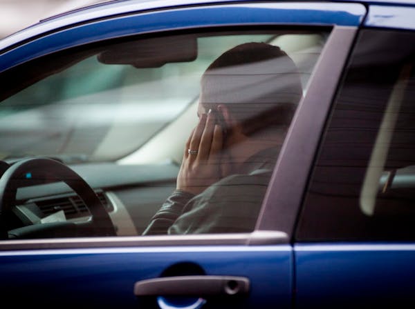 In this file photo, a man used his cell phone while driving in downtown Minneapolis.