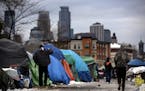 The downtown skyline can be seen after the first snow at the Minneapolis homeless encampment near Hiawatha and Cedar avenues.