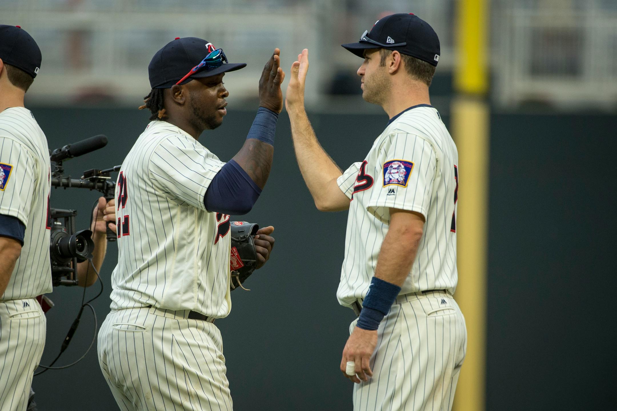 Miguel Sano and Joe Mauer, shown celebrating a 6-1 win over the Yankees on July 19, were both absent from the lineup during Saturday's 4-1 loss to the Rangers.