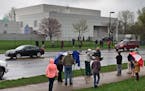 In this April 21, 2016 file photo, people stand outside entertainer Prince's Paisley Park compound in Chanhassen, Minn.
