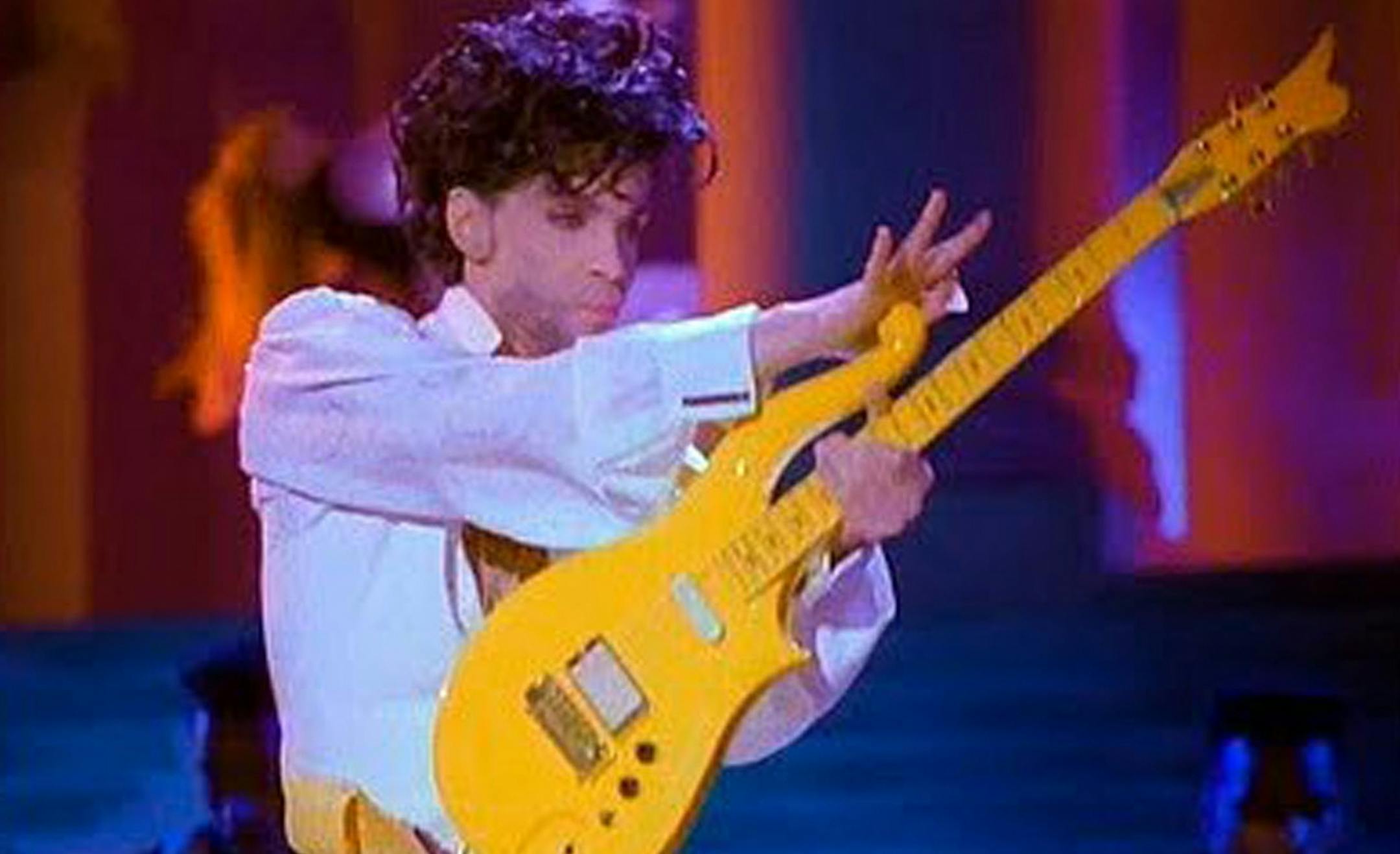 This photo provided by Heritage Auctions shows Prince playing his Yellow Cloud electric guitar. Indianapolis Colts owner Jim Irsay has purchased the Yellow Cloud electric guitar that Prince used in numerous concerts until the mid-1990's. The NFL football team owner and collector of musical instruments paid $137,500 for the guitar at an auction in Beverly Hills Saturday, June 25, 2016. Heritage Auctions, which conducted the auction, says the solid body guitar was a favorite of the late musician f