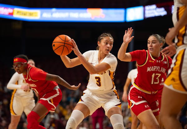 Minnesota Gophers guard Amaya Battle (3) looked for a teammate to pass to while defended by Maryland Terrapins guard Faith Masonius (13) in the first 
