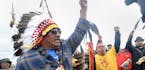 JR American Horse, left, raises his fist with others while leading a march to the Dakota Access Pipeline site in southern Morton County North Dakota. 