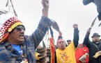 JR American Horse, left, raises his fist with others while leading a march to the Dakota Access Pipeline site in southern Morton County North Dakota. 