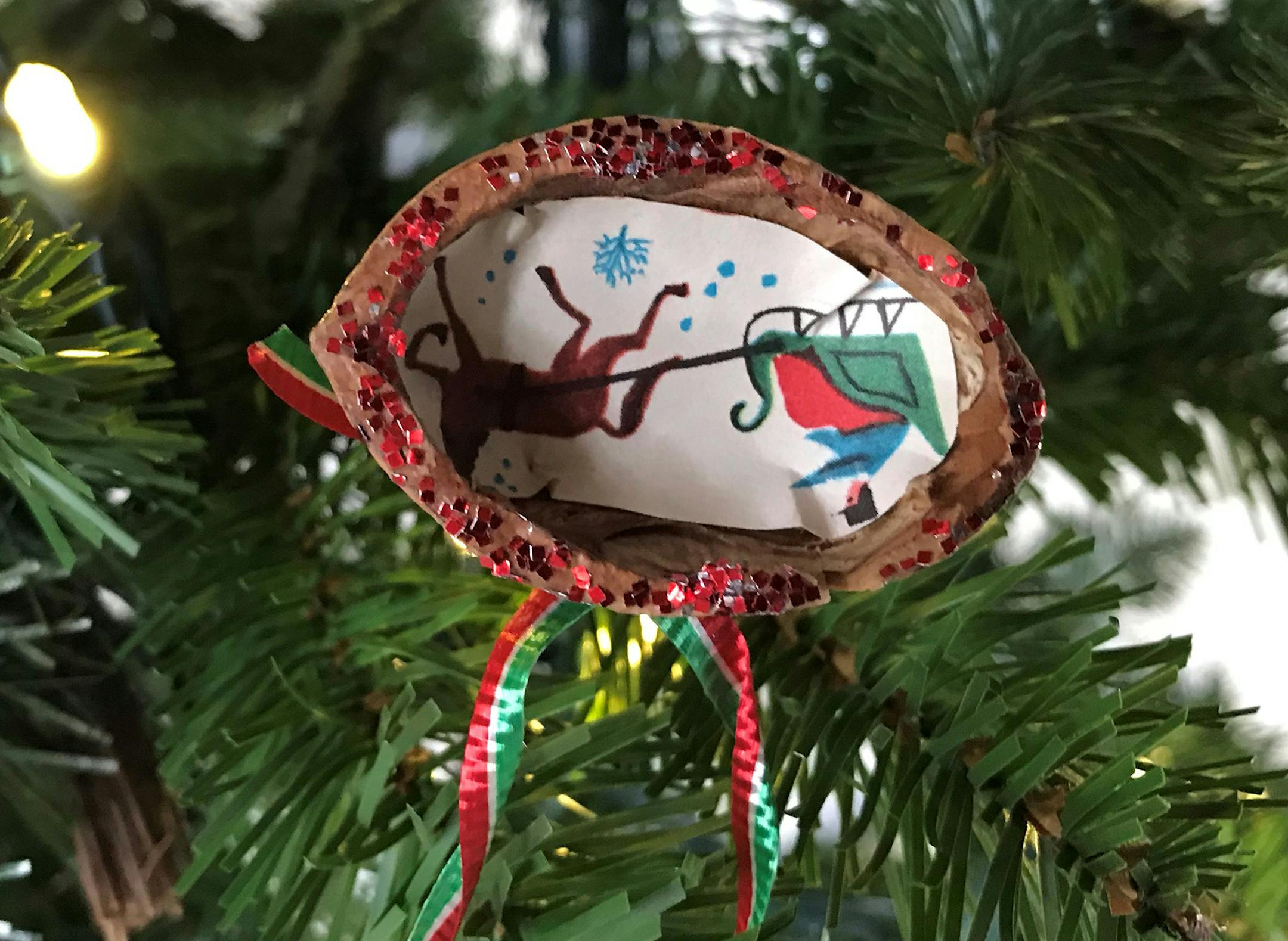 Barbara Beckman, Moorhead
Itís nothing more than a thrown-out walnut shell, a cutout from an old Christmas card, ribbon, glitter and glue. I was 8 years old, sick with tonsillitis, and disappointed that I couldnít participate in the much-rehearsed Christmas program at Zion Lutheran in Alexandria. My dad stayed home with me while my sisters and Mom went to church. As soon as they left, Dad started an unexplained flurry of activity. He set up a card table in the living room, gathered sup