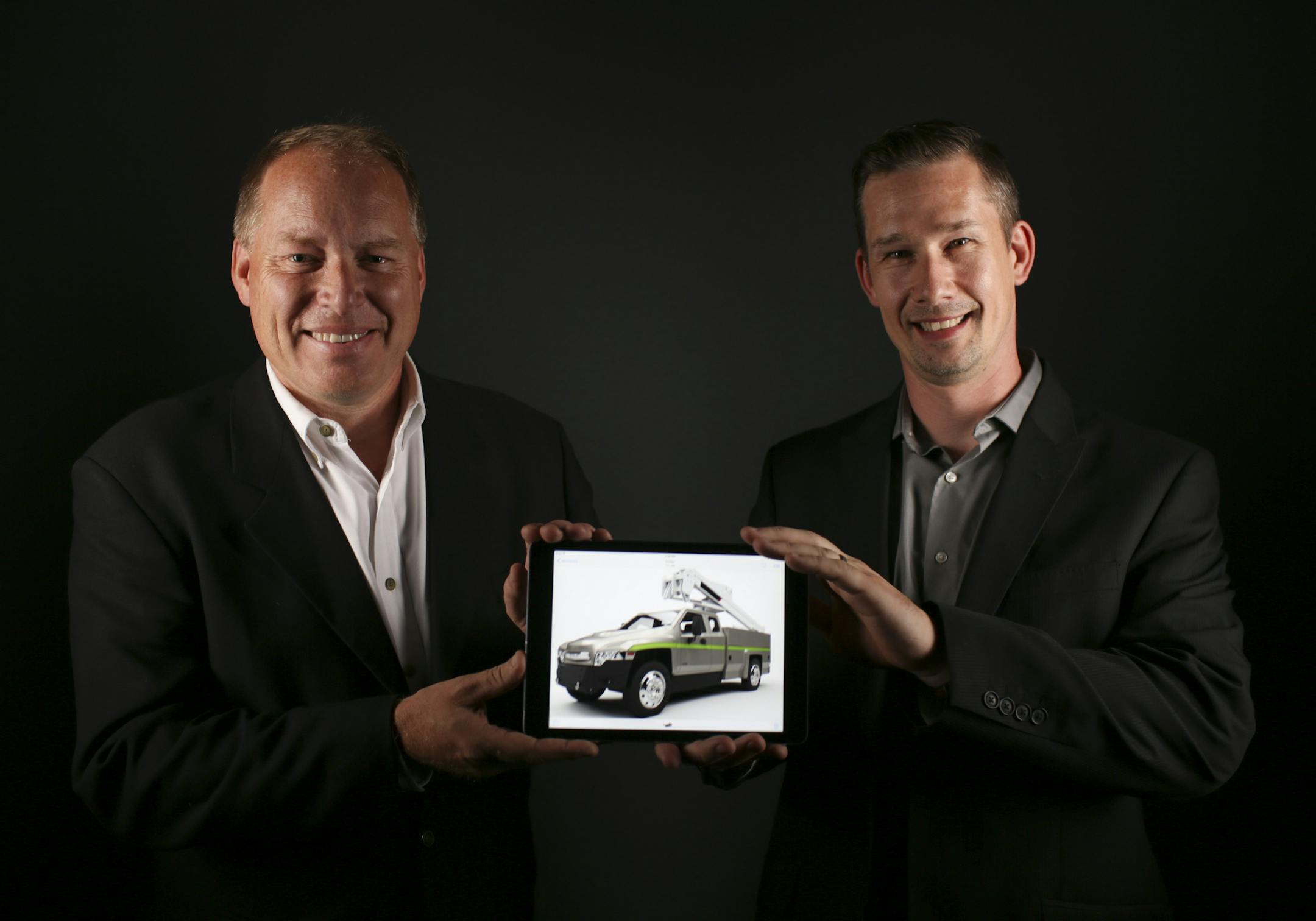 Brian Graff, left, and Bob Grinstead with a digital rendering of the Zeus, a medium-duty electric-powered truck that they hope to build in Minnesota.