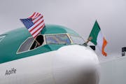 The pilots on the first Aer Lingus flight from Dublin wave the American and Irish flag after the flight parks at the gate on Monday at Minneapolis/St.