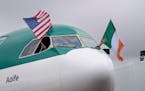 The pilots on the first Aer Lingus flight from Dublin wave the American and Irish flag after the flight parks at the gate on Monday at Minneapolis/St.