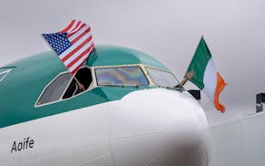 The pilots on the first Aer Lingus flight from Dublin wave the American and Irish flag after the flight parks at the gate on Monday at Minneapolis/St.