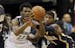 Minnesota Timberwolves guard Andrew Wiggins (22) looks to pass to a teammate under pressure from Indiana Pacers forward Paul George, right, during the