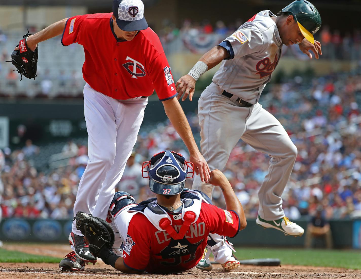 Taylor Rogers(55) passed the ball to Juan Centeno(37) who forced out Khris Davis(2) at the plate in the seventh inning.[At the Twins game against the A's at Target Field on 7/04/16. Richard Tsong-taatarii@startribune.com