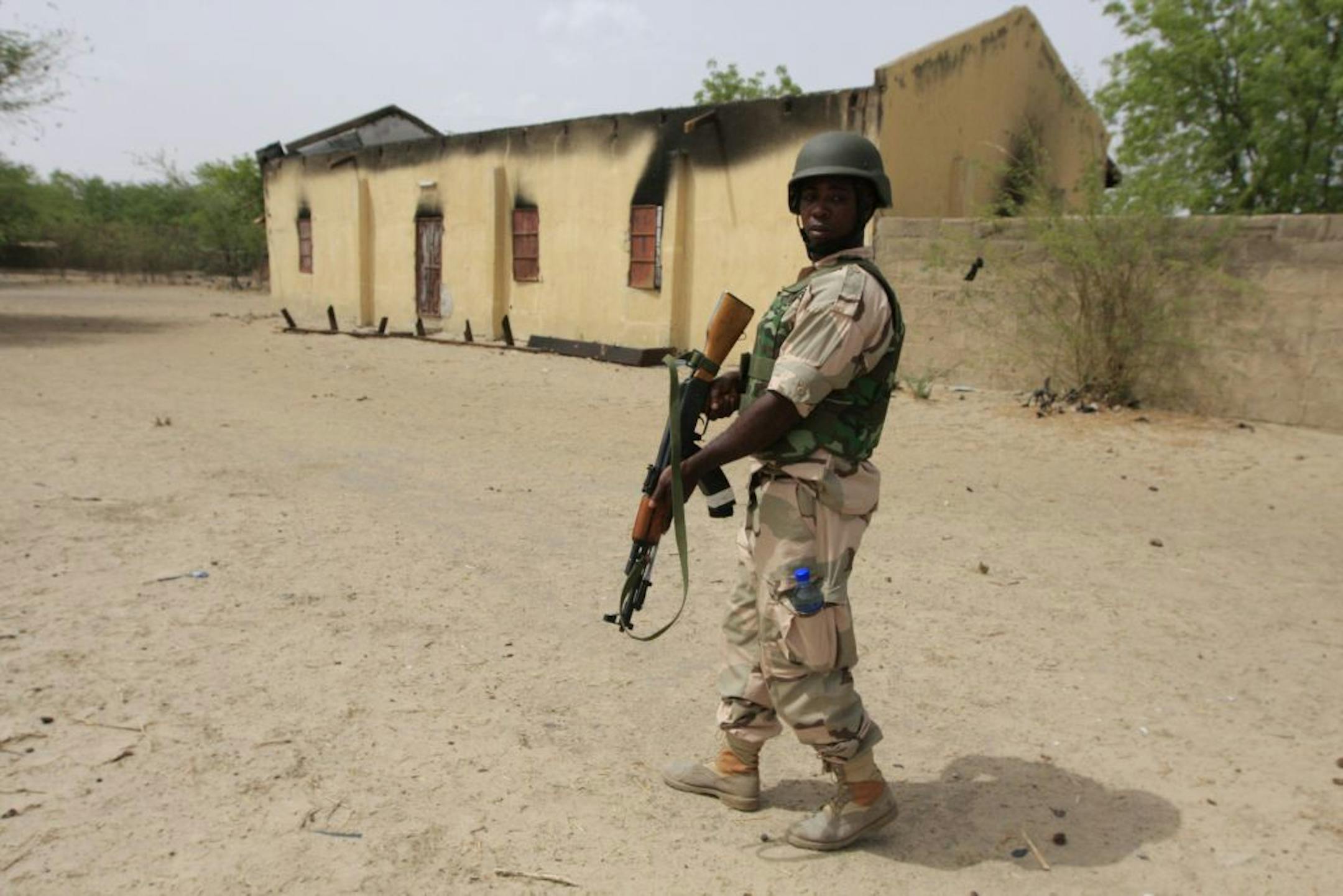 A soldier stands guard outside of a church that Islamic extremists burned in an earlier attack in Marte, Nigeria, on Wednesday, June 5, 2013.