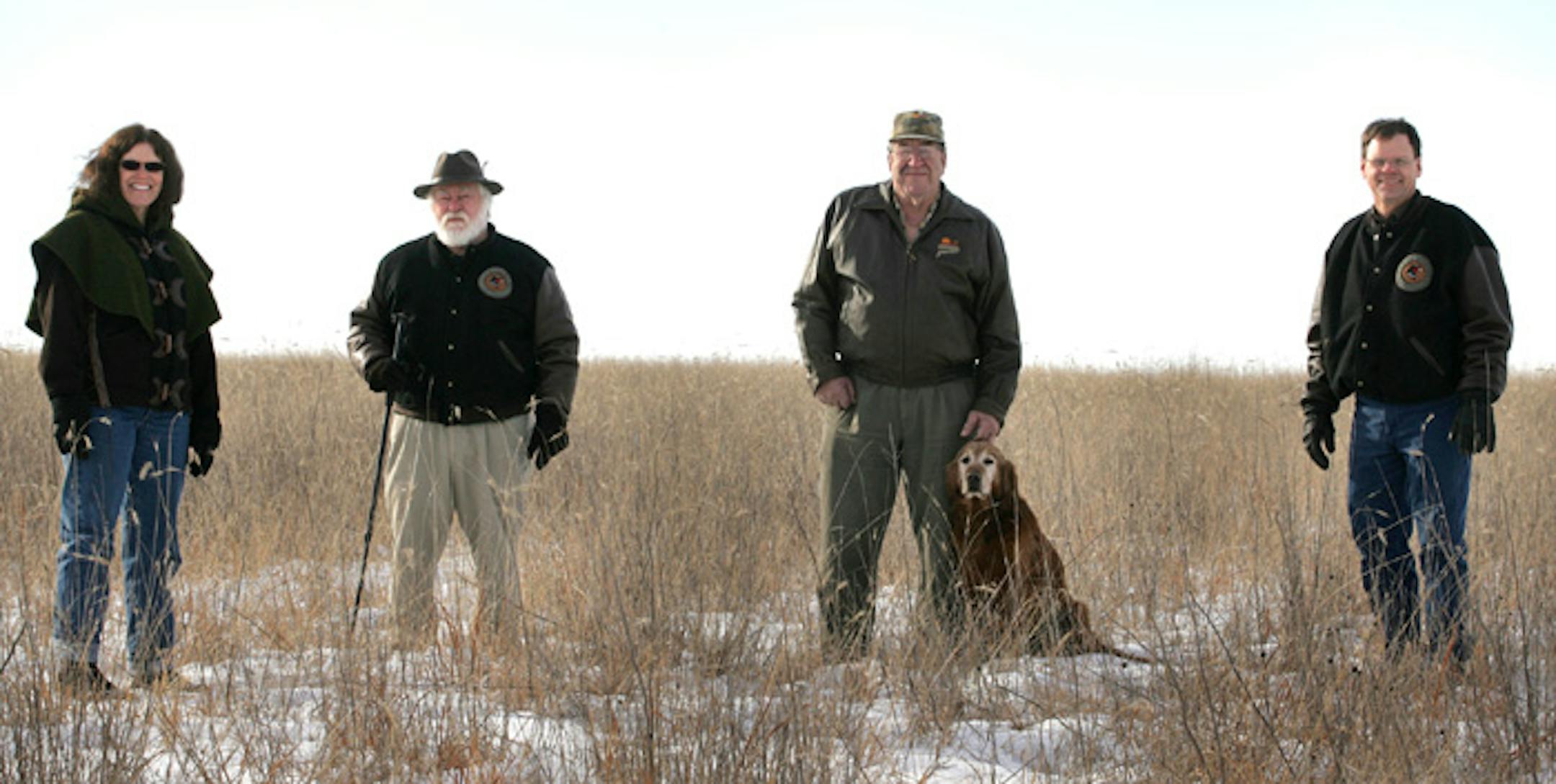 From left, Mary Mueller, of Winthrop; Virgil Voigt, of Hutchinson; Dale Kenning, of rural Hutchinson, with his dog, Colonel; and Mark Reinert, of Glencoe, are among the leaders of the McLeod County chapter of Pheasants Forever who are raising to money to buy land and conserve it for wildlife. The group posed for a portrait at a recent acquisition, 308 acres near Biscay, where they have restored native prairie grass and wetlands.