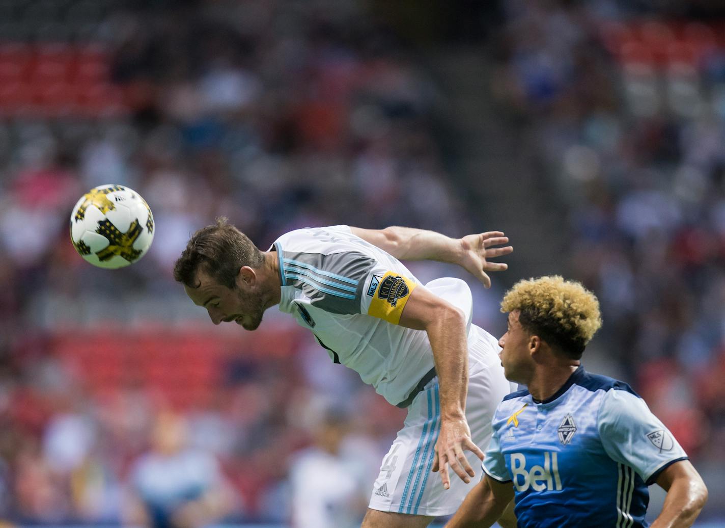 Minnesota United's Brent Kallman, left, gets his head on the ball to stop a pass intended for Vancouver Whitecaps' Erik Hurtado during the first half of an MLS soccer match Wednesday, Sept. 13, 2017, in Vancouver, British Columbia. (Darryl Dyck/The Canadian Press via AP) ORG XMIT: VCRD107