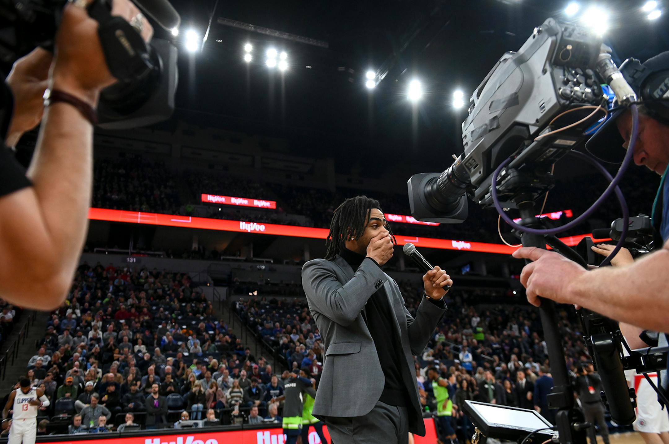 Minnesota Timberwolves guard D'Angelo Russell (0) caught held his hand over his mouth after accidentally saying an expletive as he addressed fans before Saturday night's game against the LA Clippers.