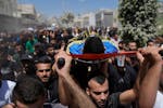 Mourners carry the bodies of four Palestinians, killed by an Israeli airstrike late Tuesday, during their funeral in the West Bank refugee camp of Nur