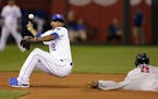 Royals shortstop Alcides Escobar was unable to hold a wide throw as the Twins' Brian Dozier stole second base during the ninth inning Tuesday. The Roy