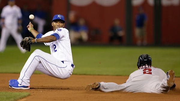 Royals shortstop Alcides Escobar was unable to hold a wide throw as the Twins' Brian Dozier stole second base during the ninth inning Tuesday. The Roy