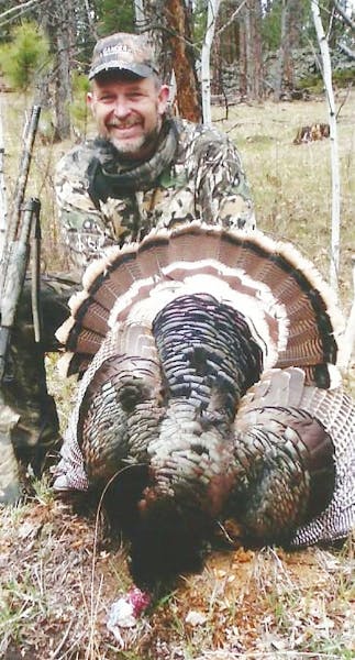 Tom Glines of Coon Rapids with a gobbler he shot in the Black Hills in 2010. Glines has hunted wild turkeys in 28 states. Photo courtsey of Tom Glines