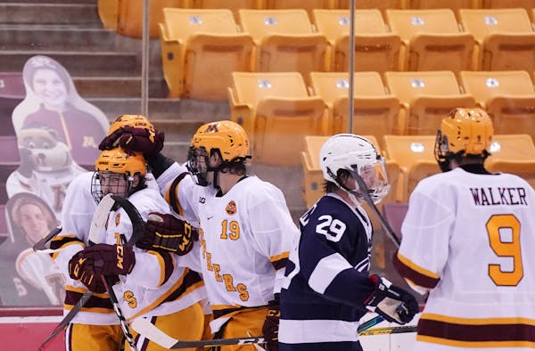 Gophers winger Brannon McManus (7) was congratulated by his teammates after he scored a goal in Friday's game vs. Penn State.