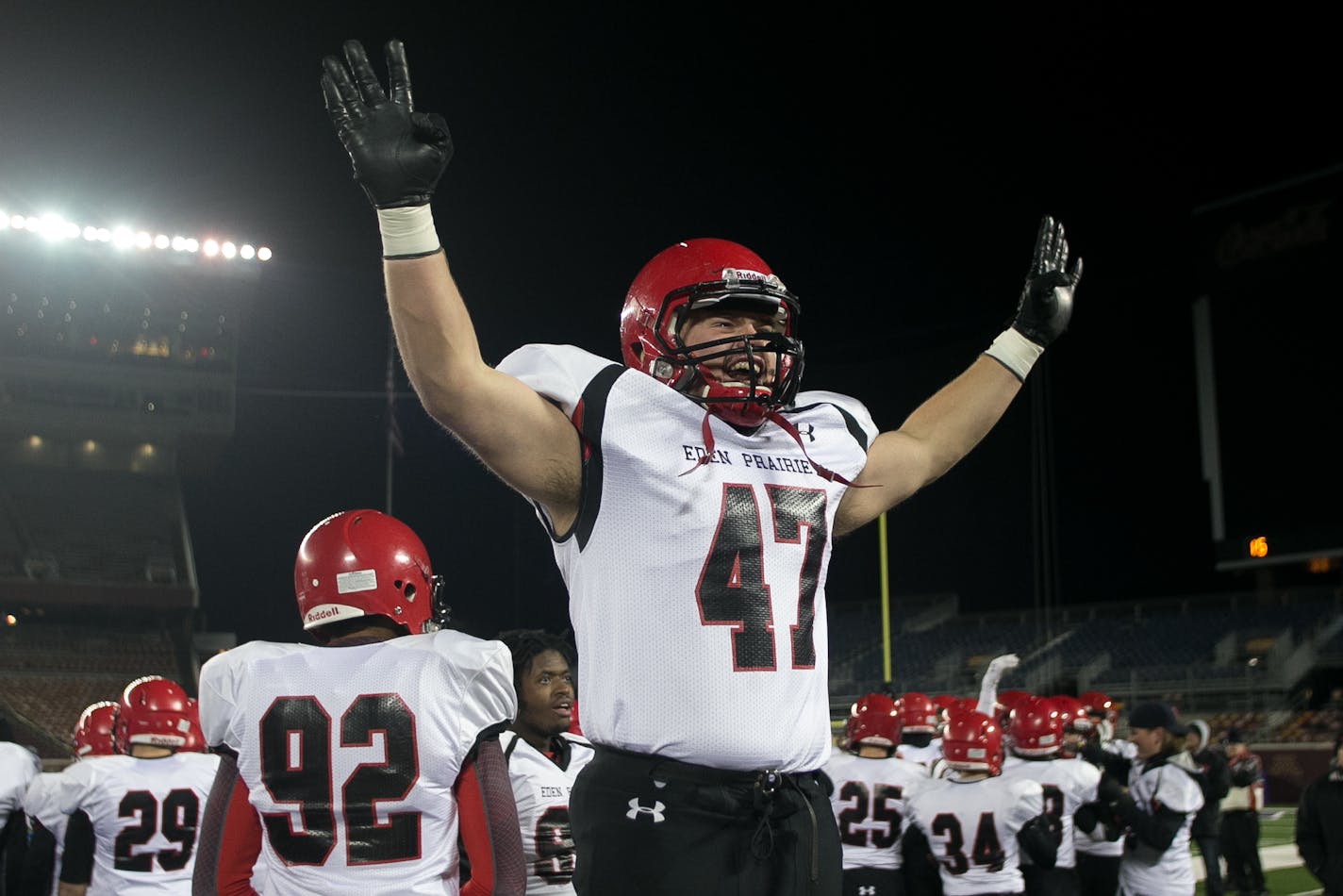 Eden Prairie defensive end Jake Halvarson puts up his hands with four fingers to represent his team's fourth title in a row to the student section Friday night. ] AARON LAVINSKY � aaron.lavinsky@startribune.com Totino-Grace takes on Eden Prairie in the Class 6A Prep Bowl Friday, Nov. 21, 2014 at TCF Bank Stadium.