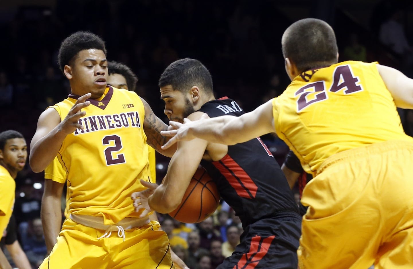 Rutgers' Bishop Daniels, center, tries to squeeze between Minnesota's Nate Mason, left, and Joey King during the first half of an NCAA college basketball game Tuesday, Feb. 23, 2016, in Minneapolis.