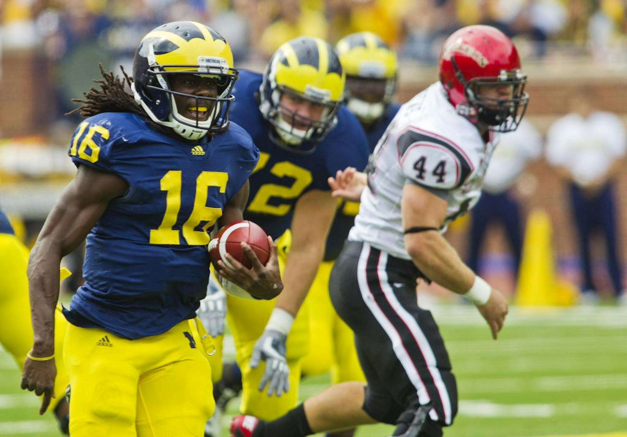 Though Michigan QB Denard Robinson (16) is known for his legs, his arm is dangerous, too.