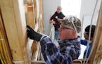 Gov. Tim Walz worked Tuesday with Twin Cities Habitat for Humanity site supervisor Jesse Dinh, right, and fellow volunteer, Deluxe Corp. CEO Barry McC