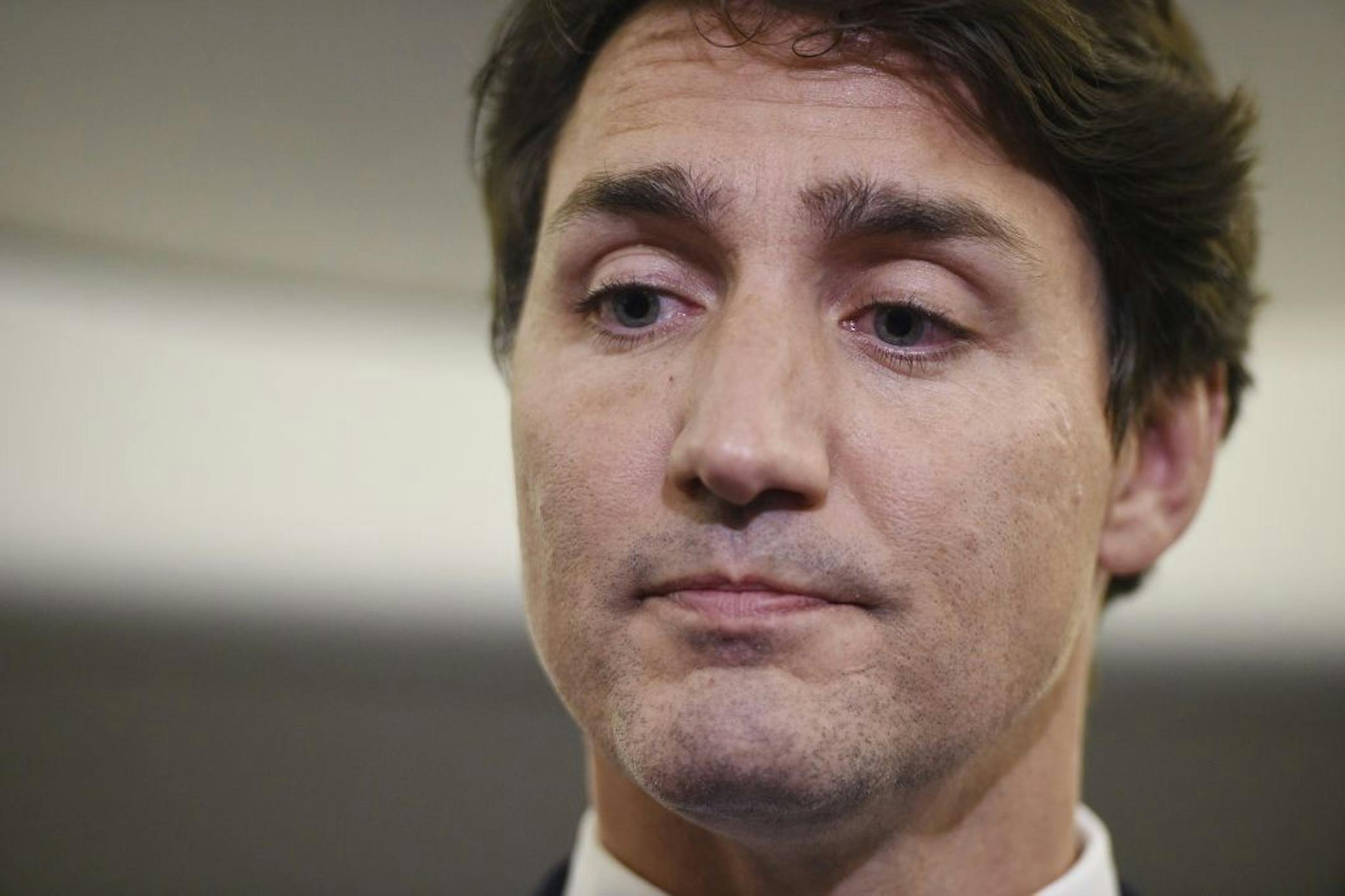 Canadian Prime Minister and Liberal Party leader Justin Trudeau reacts as he makes a statement in regards to a photo coming to light of himself from 2001, wearing "brownface," during a scrum on his campaign plane in Halifax, Nova Scotia, Wednesday, Sept. 18, 2019.