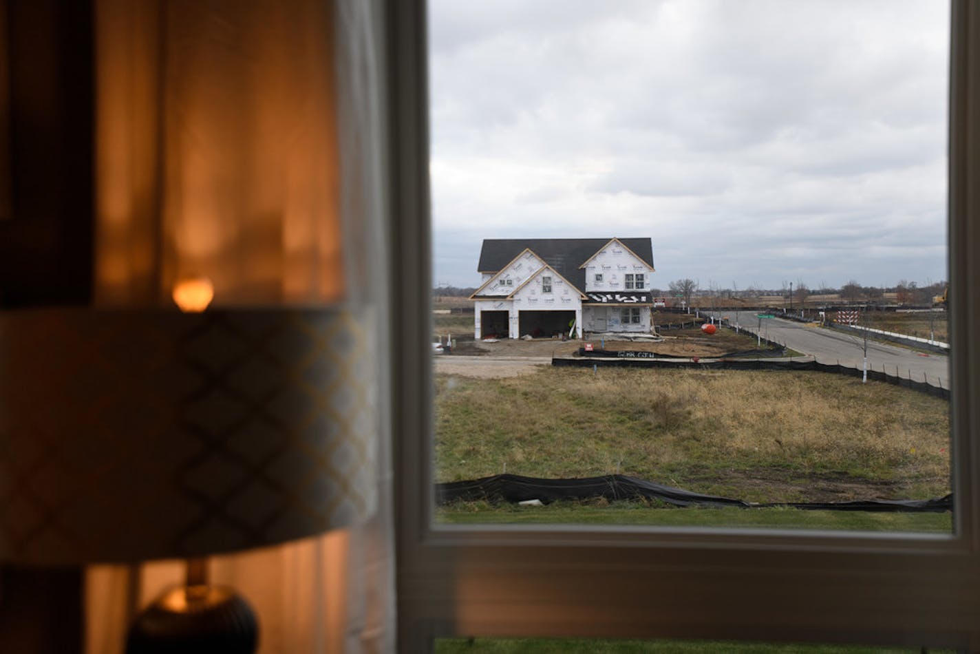 A home under construction in the Summerlin neighborhood of Woodbury as seen through the living room window of a model home. Home sales in the Twin Cities metro during October were flat compared with last year, but not for lack of interest.