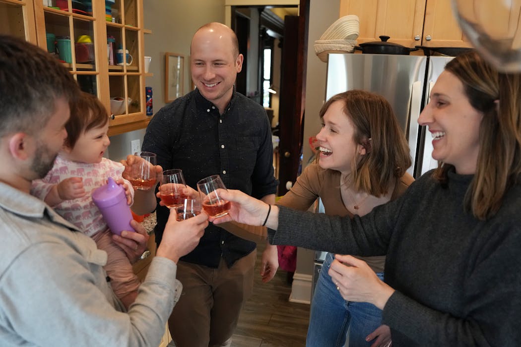 Co-homeowners, from left, Tye Schulke, holding his daughter Esme, 1, Sean Boley and spouse Sara Kemper, and Betsy Ohrn, Schulke’s spouse, make a toast on Friday, their last night living together in a home they co-purchased in 2017 in St. Paul.