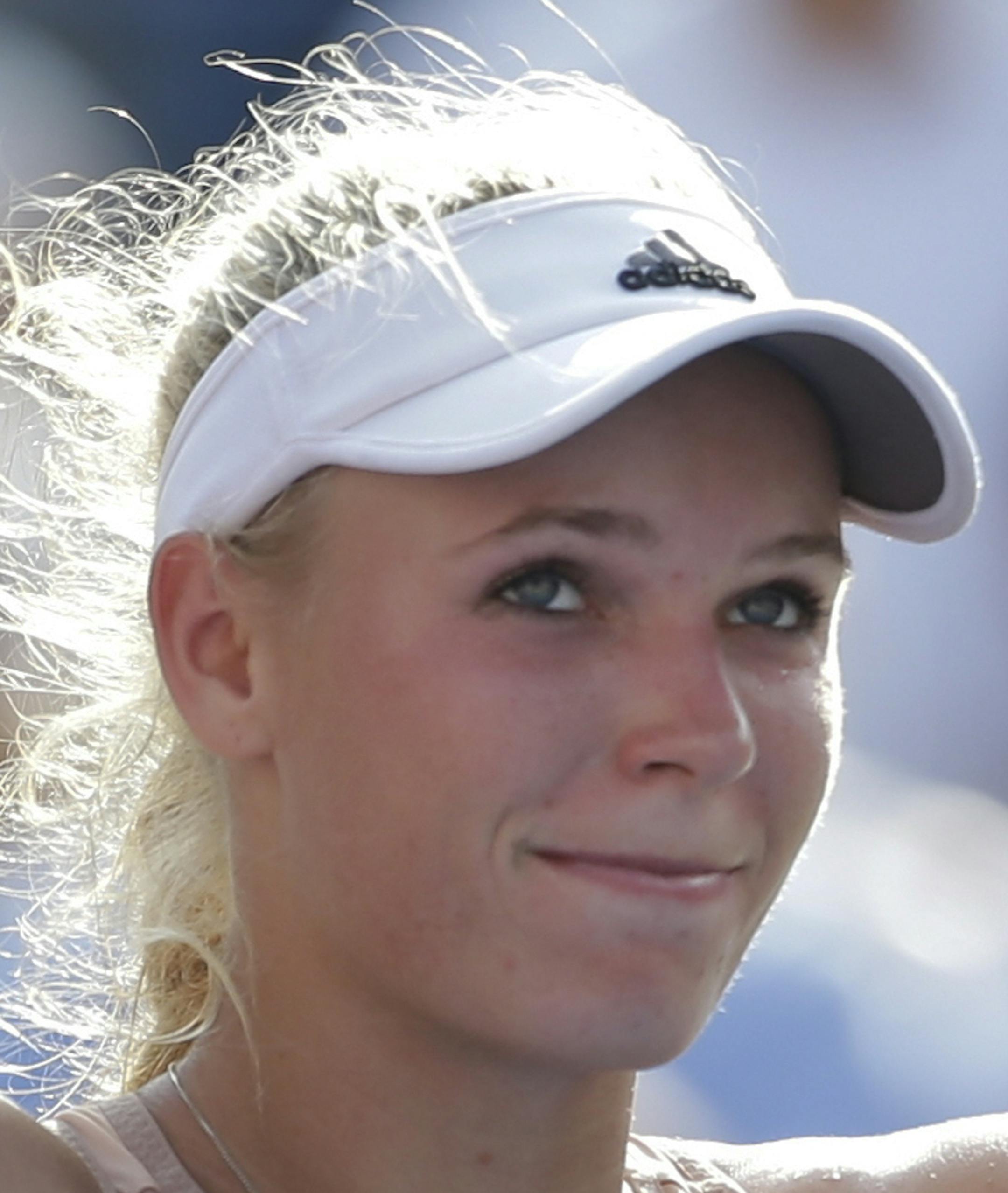 Caroline Wozniacki, of Denmark, waves to the crowd after winning by forfeit over Peng Shuai, of China, during the semifinals of the 2014 U.S. Open tennis tournament, Friday, Sept. 5, 2014, in New York. Peng retired after leaving the court in a wheel chair with a leg cramp. (AP Photo/Darron Cummings)