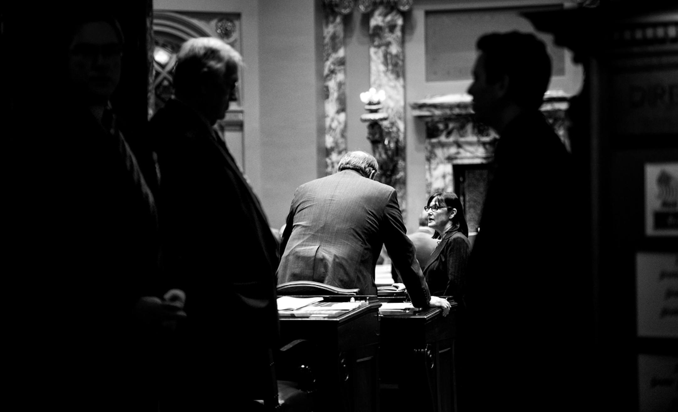 Senate Majority Leader Tom Bakk talked with Sen. Terri Bonoff DFL-Minnetonka on the mostly empty Senate floor before the start of the day's session. The Senate Sergeants at Arms stood ready to call the Senators to the floor ] GLEN STUBBE * gstubbe@startribune.com Monday, March 31, 2014.