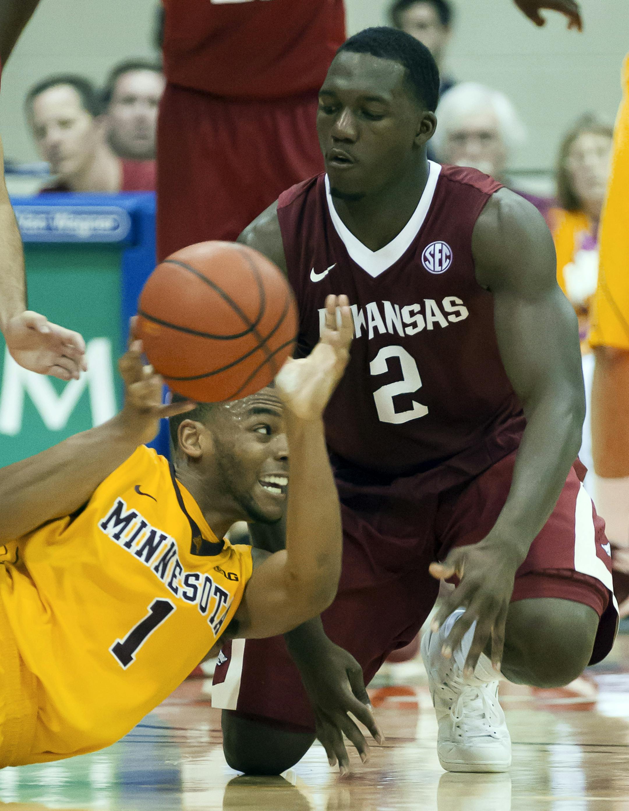 Minnesota guard Andre Hollins (1) and Arkansas forward Alandise Harris (2) battle to control a loose ball in the second half of an NCAA college basketball game at the Maui Invitational on Tuesday, Nov. 26, 2013, in Lahaina, Hawaii. Arkansas won 87-73. (AP Photo/Eugene Tanner)