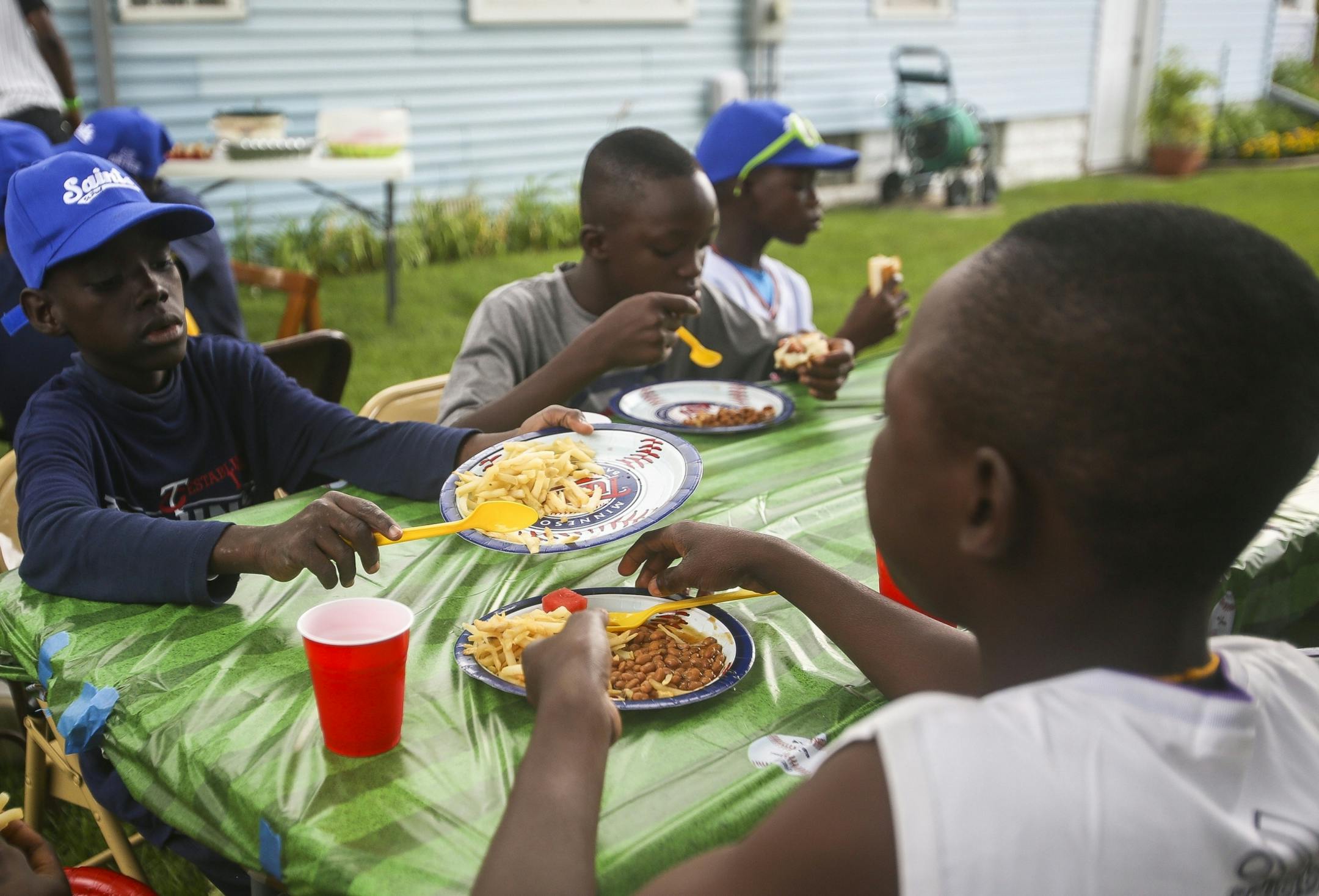 Joseu Acakpo, left, shares his remaining french fries with teammate Enock Fambo, right, at the house of volunteers Tim and Diane Keefe on Monday, August 1, 2016 in Robbinsdale.