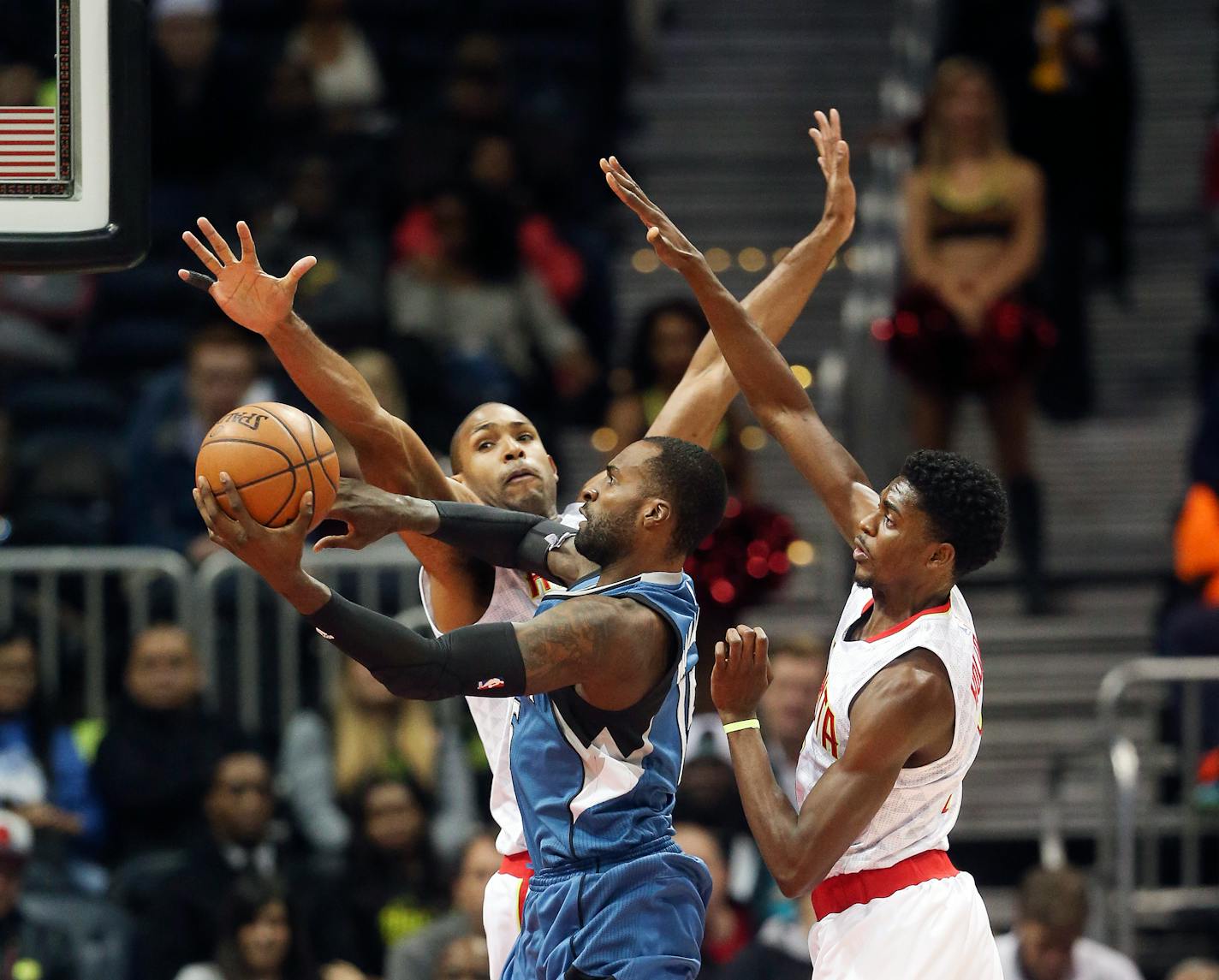 Timberwolves forward Shabazz Muhammad, center, shot against the Hawks' Al Horford, left, and Justin Holiday in the first half of Minnesota's 117-107 victory Monday.