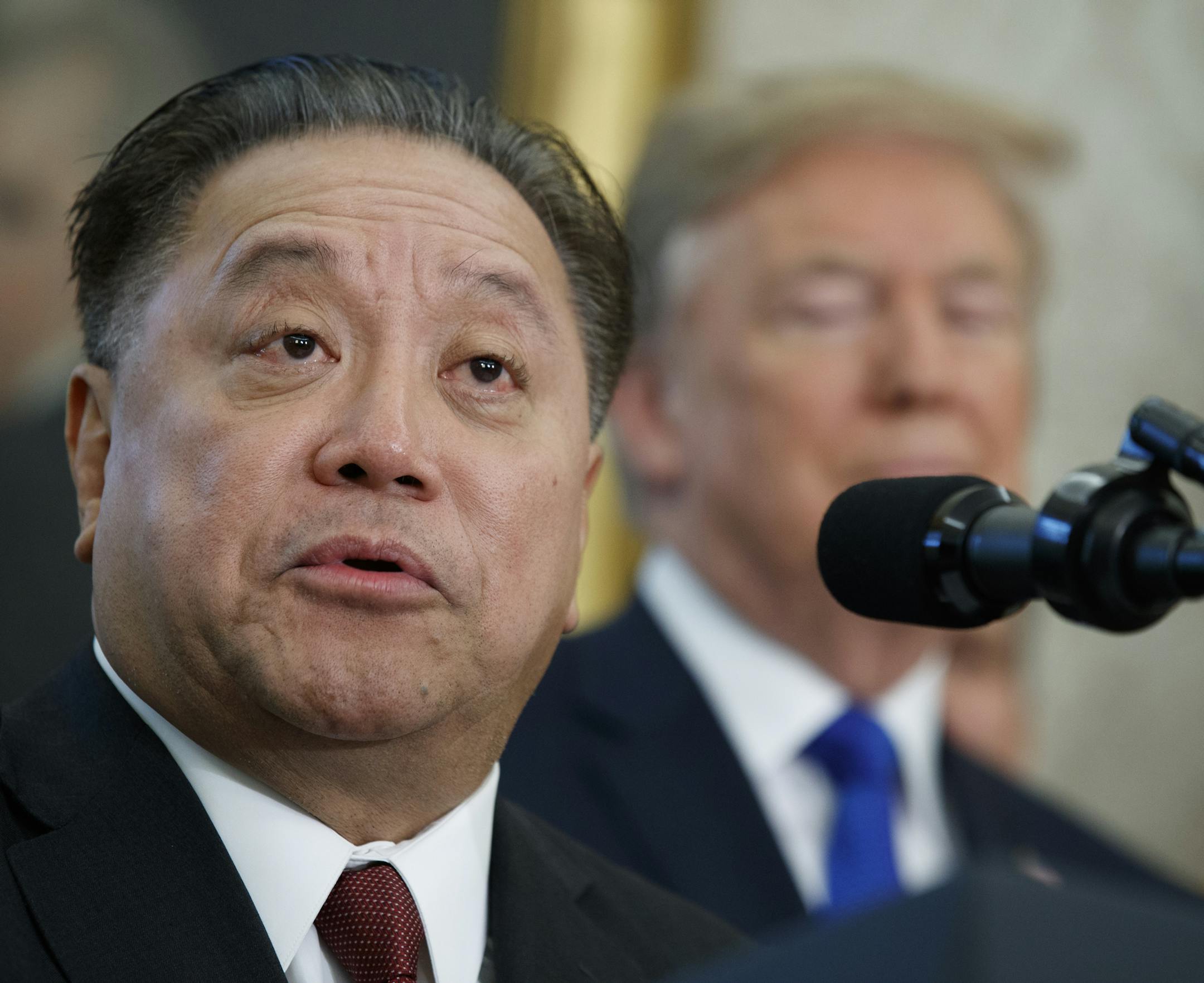 FILE - In this Thursday, Nov. 2, 2017, file photo, Broadcom CEO Hock Tan speaks as President Donald Trump listens during an event to announce the company is moving its global headquarters to the United States, in the Oval Office of the White House, in Washington. Broadcom is making an unsolicited, $130 billion offer for rival chipmaker Qualcomm. (AP Photo/Evan Vucci, File)