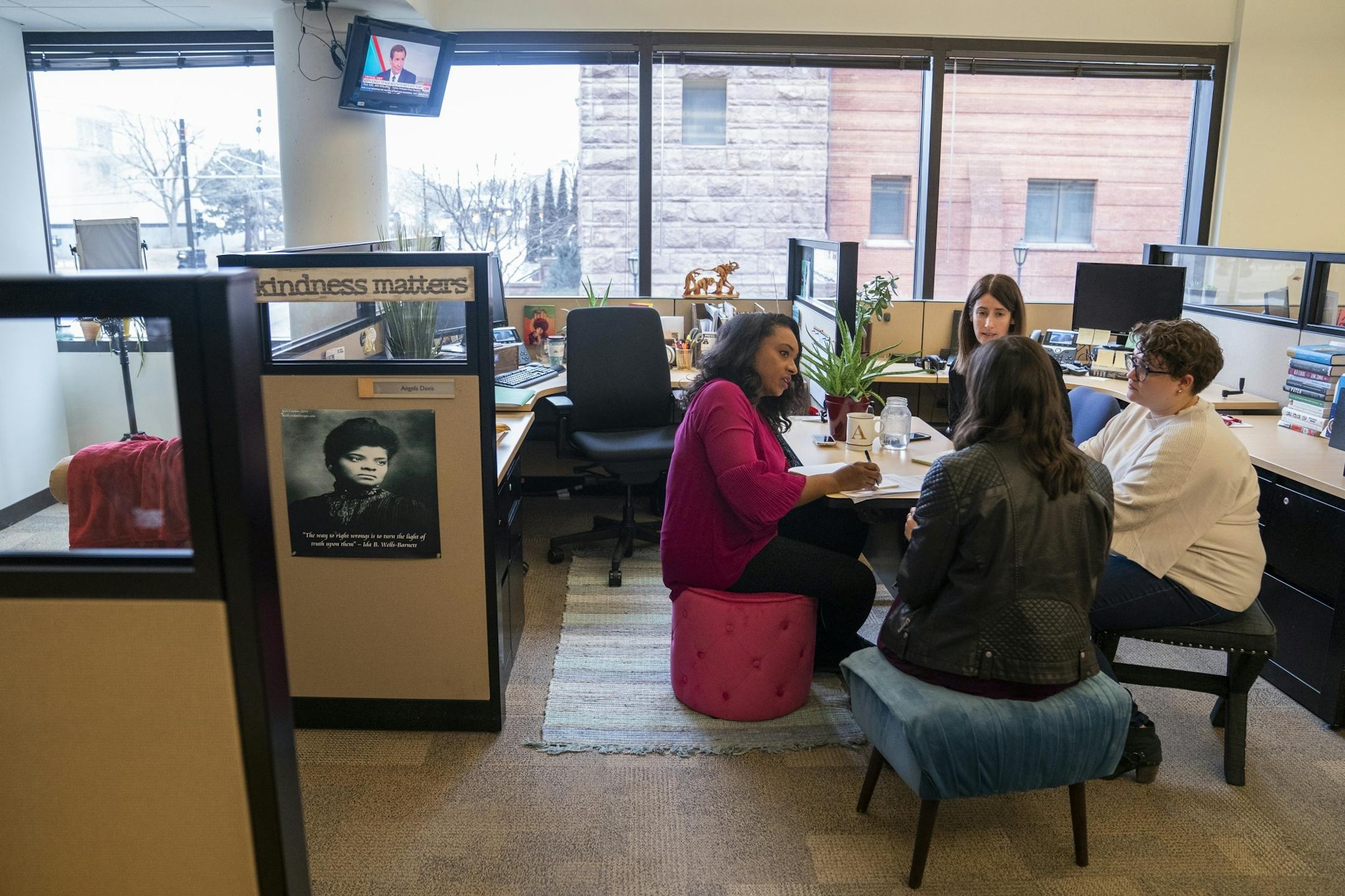 MPR host Angela Davis, from left, meets with senior producer Julie Siple, top, assistant producer Manda Lillie, right, and associate producer Karen Zamora, back to camera, during their planning huddle after the show.