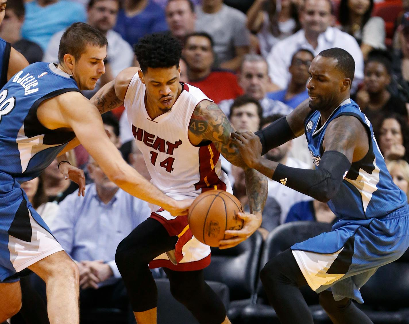 Timberwolves forward Nemanja Bjelica, left, and forward Shabazz Muhammad stripped the ball from Heat guard Gerald Green during the first half Tuesday.