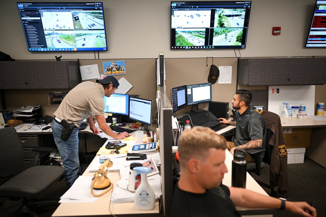 Ramsey County Deputy Sheriff Joe Miller, left, and intelligence analyst Sanjay Sivarajah, back right, both with the county’s Carjacking and Auto Theft (CAT) unit, worked Wednesday at the Ramsey County Law Enforcement Center in St. Paul.